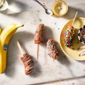 Sucettes de banane glacées enrobées de chocolat et décorées de vermicelles (colorés)