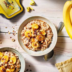 Porridge chaud avec banane cuite, fèves de cacao et noisettes